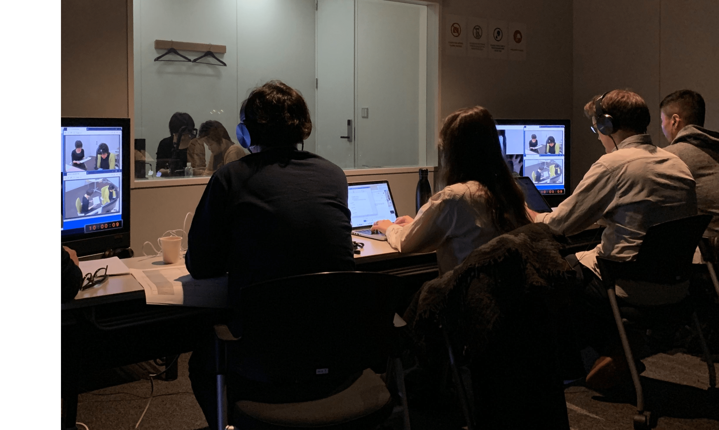 A group of people sitting at a desk in front of a computer