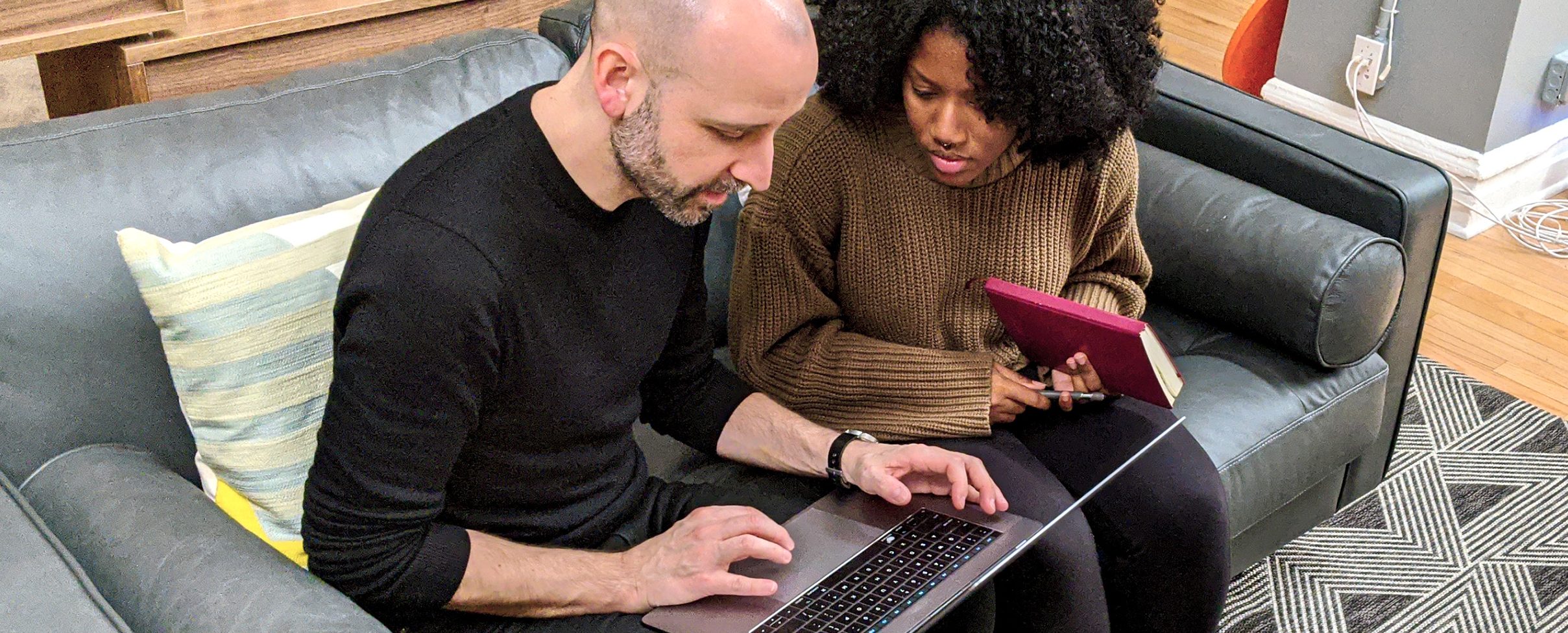 A man sitting at a table using a laptop computer