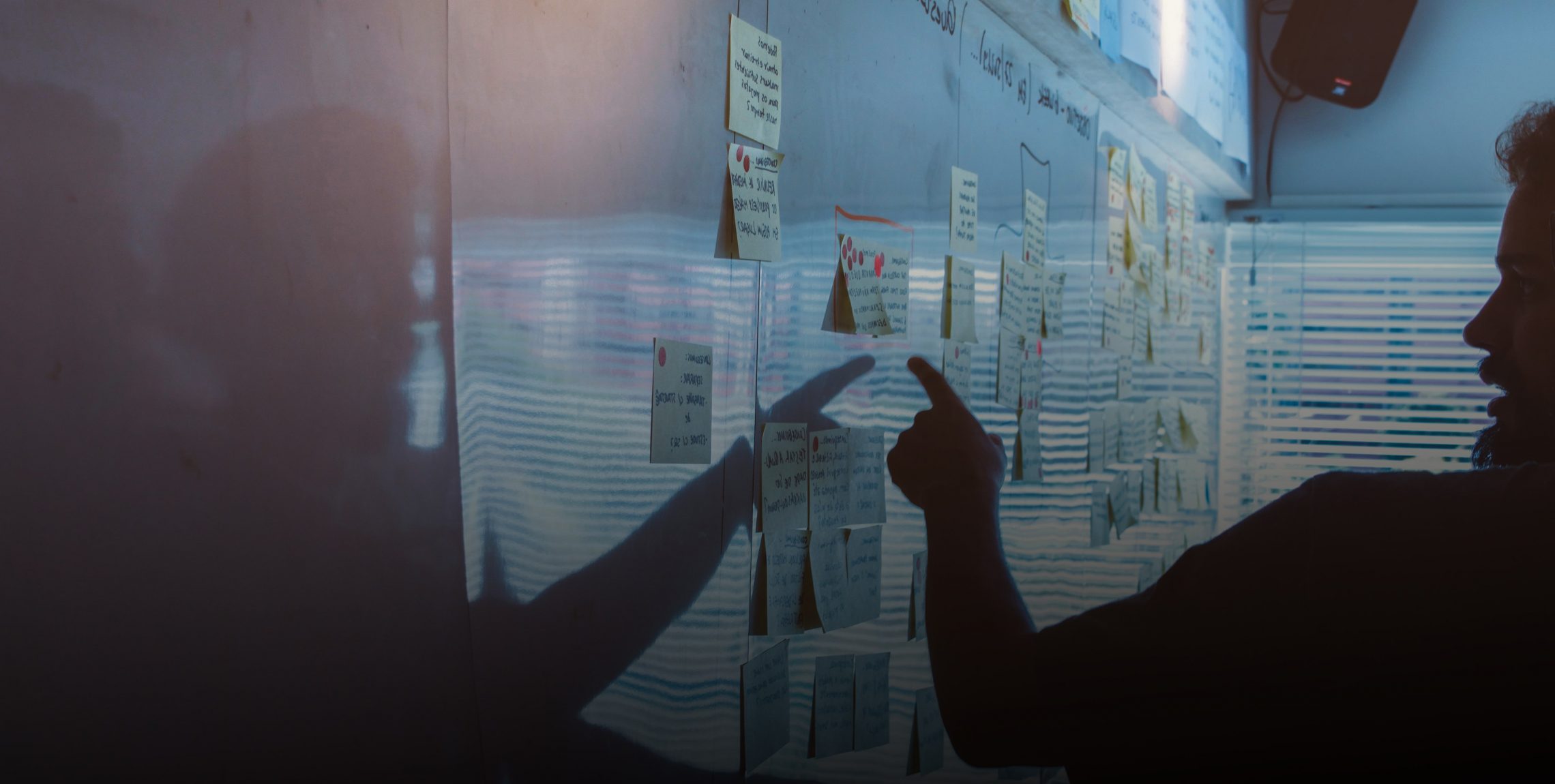 UX Designer placing post-it notes on a whiteboard