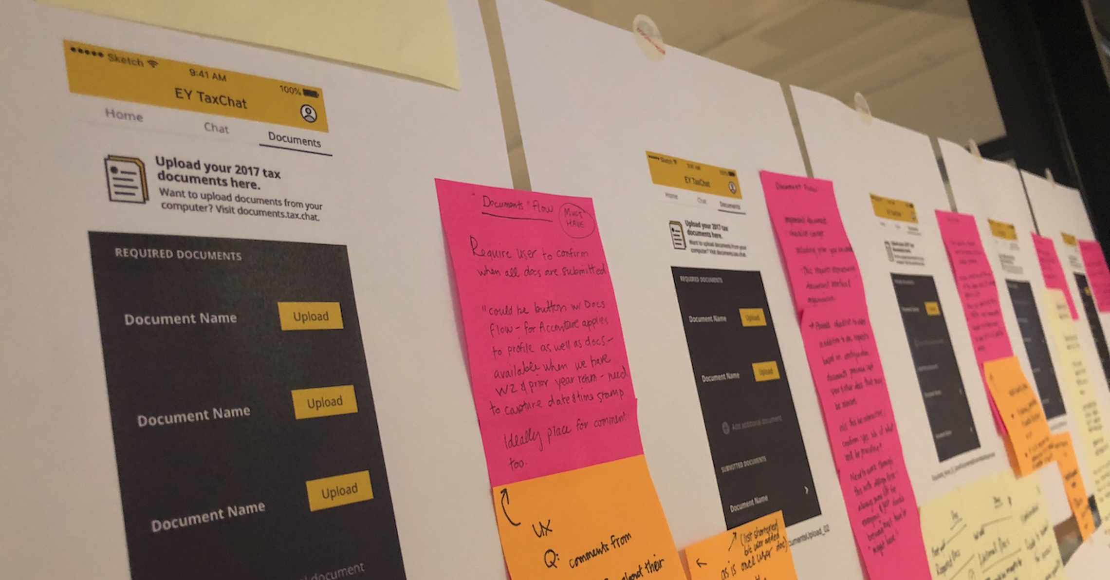 wireframes and post-it notes from a design research workshop posted on a window