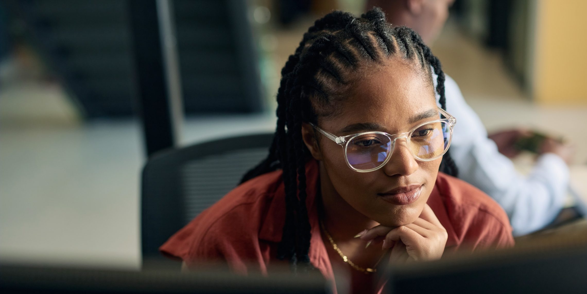 Professional focused on a computer screen reflecting how agents and brokers are using AI to analyze data and complete daily tasks